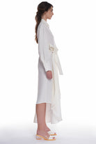 ASYMMETRICAL LONG SHIRT-DRESS WITH RUFFLE ON THE SIDE, OPEN COLLAR, TIED WITH A BELT, BUTTONING ON THE BACK