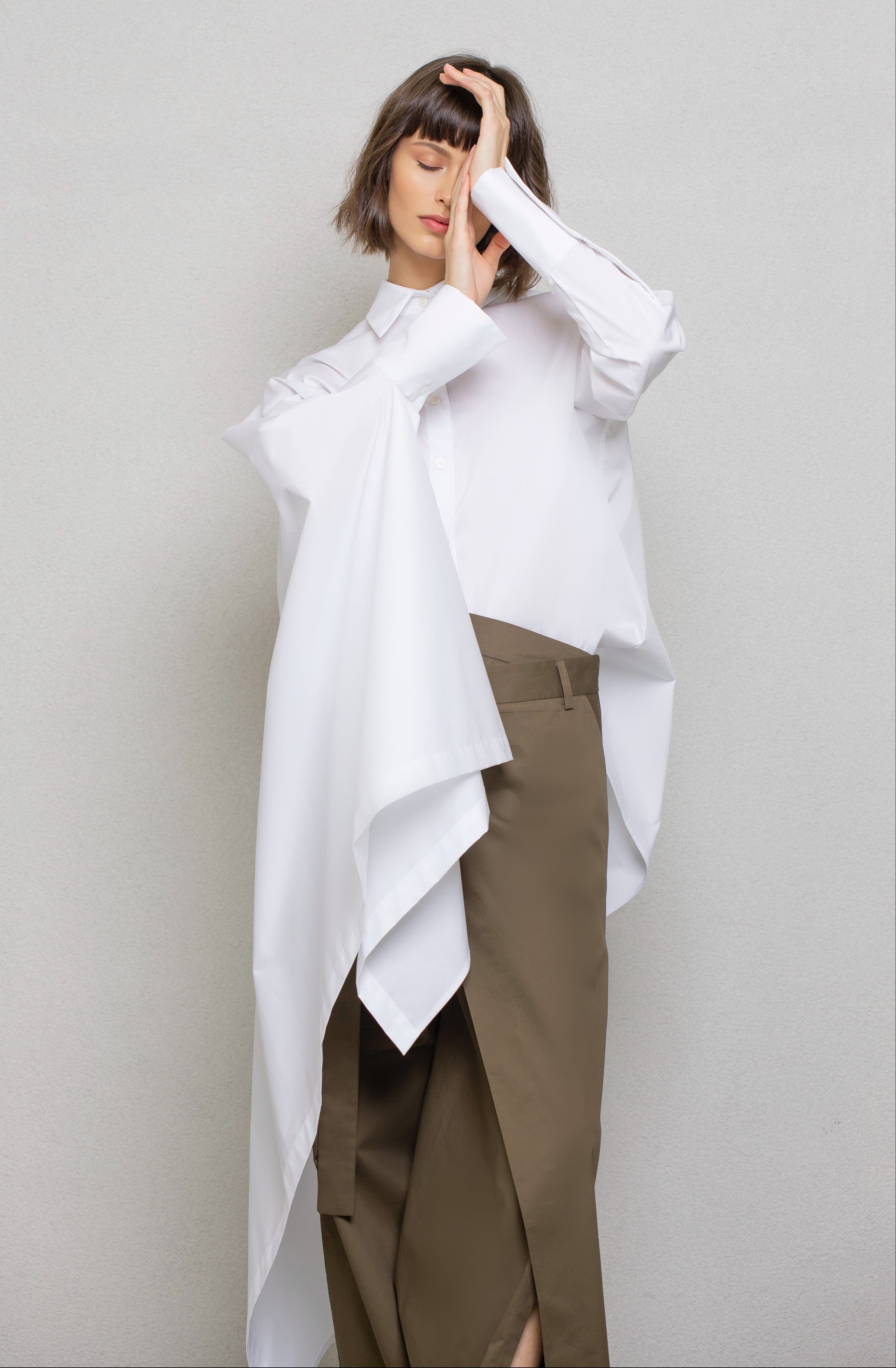 Woman wearing a white oversized shirt and brown pants 