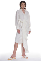 ASYMMETRICAL LONG SHIRT-DRESS WITH RUFFLE ON THE SIDE, OPEN COLLAR, TIED WITH A BELT, BUTTONING ON THE BACK