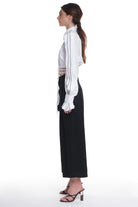 LONG SLEEVE SHIRT WITH RUFFLES ON THE SIDES OF THE SLEEVES, HIGH COLLAR. IT IS TIED AT THE WAIST.