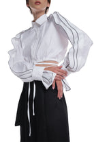 LONG SLEEVE SHIRT WITH RUFFLES ON THE SIDES OF THE SLEEVES, HIGH COLLAR. IT IS TIED AT THE WAIST.
